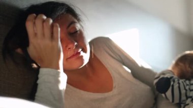 Mother touching forehead. Parent covering face in morning in bed