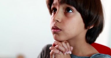 Çocuk Tanrı 'ya dua ediyor, ruhani çocuk elleri birarada, inançlı çocuk imanla gökyüzüne bakıyor.