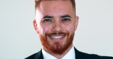 İdari İrlandalı kızıl saçlı adam fotoğraf çekimine gülümsüyor. İş adamı yakışıklı karizma gülümsemesi