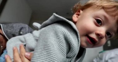 Happy baby with fun mom in bed smiling and laughing. Mother and child bonding