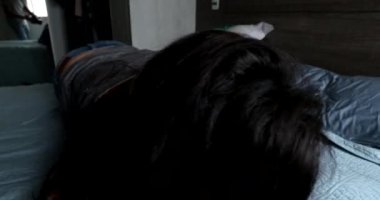 Mother and baby rolling together in bed, cute moment loving caring relationship between mom and child