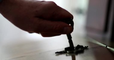 Hand inserting key in antique furniture. Close-up person removes key