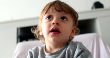 Portrait baby boy hypnotized by screen, child face watching cartoon