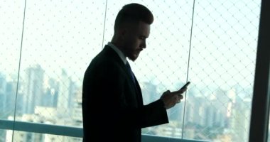 Gizli iş adamı arka planda şehirli akıllı telefon kullanıyor.