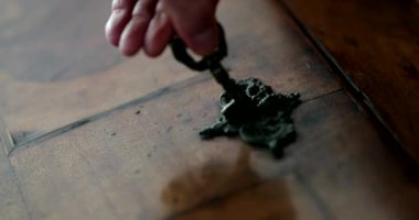 Hand inserting key in antique furniture