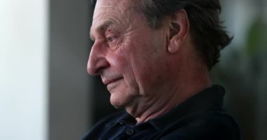 Tired older man yawning and rubbing face with hands. Pensive senior person feeling exhausted