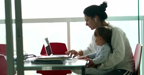 Mother Multi Tasking Holding Baby Infant Using Computer Laptop Home — Stockvideo