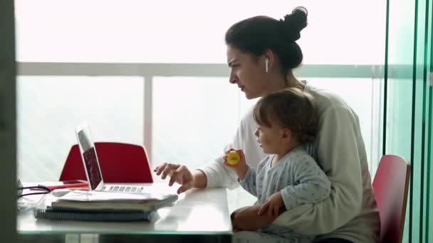 Мать Многозадачная Держит Младенца Использует Ноутбук Дома Откровенная Подлинная Реальная — стоковое видео