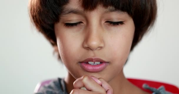 祈りを捧げる子供の男の子 ジェスチャーで手で祈る子供の肖像画の顔 — ストック動画