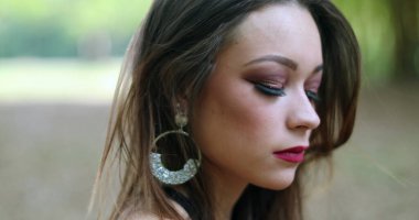 Düşünceli, yalnız, üzgün genç bir kadının portresi. Açık hava parkında düşünceli güzel kız.