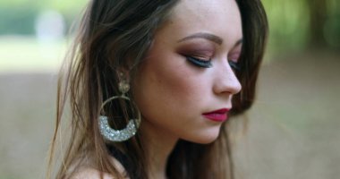 Düşünceli, yalnız, üzgün genç bir kadının portresi. Açık hava parkında düşünceli güzel kız.