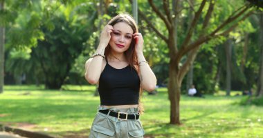 Güzel kız açık hava parkında poz verirken rahat hissediyor.