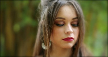 Saçlarını kameraya göre ayarlayan güzel İspanyol kız. Kahraman 20 'li yaşlarda genç bir kadın açık hava parkında