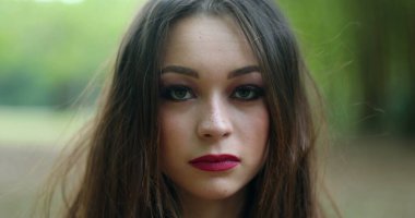 20 'li yaşlarda, açık havada fotoğraf çeken genç bir kadının portresi.