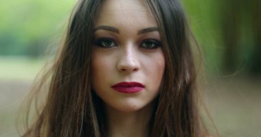 20 'li yaşlarda, açık havada fotoğraf çeken genç bir kadının portresi.