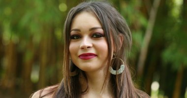 Güzel milenyum kızı gülümsüyor. Kameraya bakan genç kadın portresi