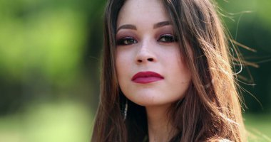 Parkta poz veren sevimli İspanyol kız kameraya bakıyor. Kendine güvenen Latin bir genç kadın.