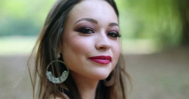 Güzel İspanyol kız portresi üzgün, duygularını değiştiriyor, mutlu oluyor ve kameraya gülümsüyor.