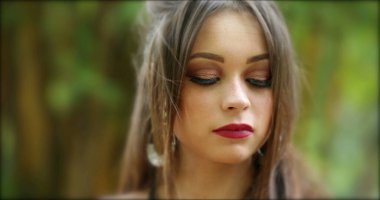 Saçlarını kameraya göre ayarlayan güzel İspanyol kız. Kahraman 20 'li yaşlarda genç bir kadın açık hava parkında