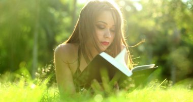 Açık hava parkında kitap okuyan güzel bir kadın.