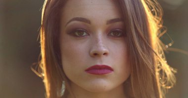 Ciddi, güzel bir milenyum kızı doğrudan kameraya bakıyor. 20 'li yaşlarda genç bir kadının portresi.