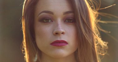 Ciddi, güzel bir milenyum kızı doğrudan kameraya bakıyor. 20 'li yaşlarda genç bir kadının portresi.