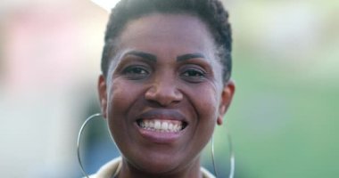 African woman smiling at camera. Mixed race person portrait face close-up, casual and real people