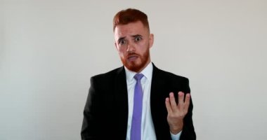 Üzgün adam kameraya tartışıyor, kızıl saçlı iş adamı kameraya kızgın konuşuyor.