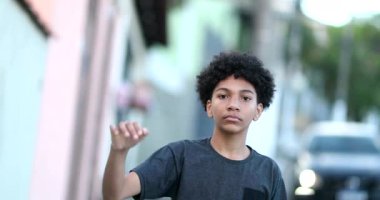 Little boy raises fist in air in protest. Mixed race child political protester raising fist