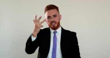 Üzgün adam kameraya tartışıyor. Kızgın iş adamı kameraya konuşuyor, elleriyle işaret ediyor.