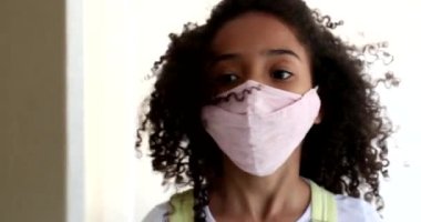 Küçük kız, Coperid-19 yüz maskesi takıyor. Melez etnik köken