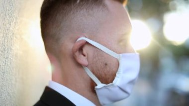 Man wearing covid surgical mask outside. Person turning head, looking to camera wearing pandemic preventive mask against pandemic