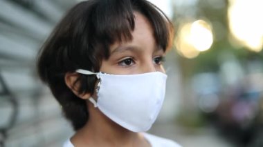 Portrait of child boy wearing surgical mask prevention against pollution or pandemic outdoors