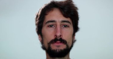 Portrait of serious young man close-up face. Casual person looking at camera