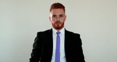 Beyaz adam İrlandalı görünümlü iş adamı kameraya gülümsüyor.