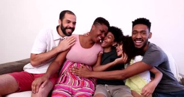 African family hugging in home sofa. Mixed race black parents and children embrace, love and affection