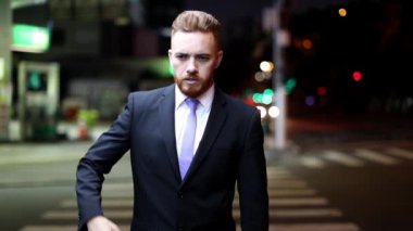 Tense businessman walking in city at night. Frustrated worried man undressing suit and tie. Stress man in finance