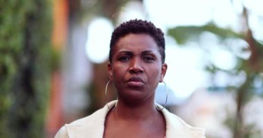 Confident serious African woman 40s walking towards camera in street