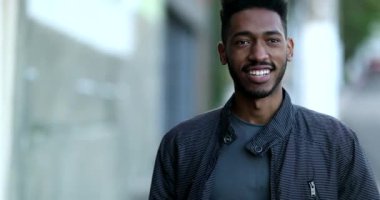 Kendinden emin Afrikalı genç adam gülümsüyor.