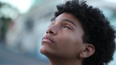 Hopeful child opening eyes to sky smiling, close-up kid face