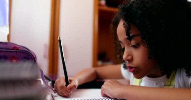 Little girl writing notes making a mistake and erasing content. Child doing homework