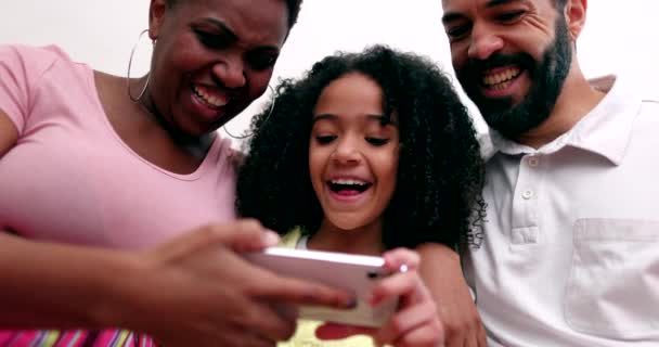 Happy Interracial Couple Mixed Race Little Girl Looking Cellphone Laughing — 图库视频影像