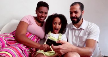 Mixed race parents and little girl posing for selfie on cellphone