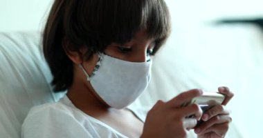 Çocuk salgın sırasında video oyunu oynuyor