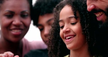 Komik mutlu aile cep telefonuna bakıp gülüyor.