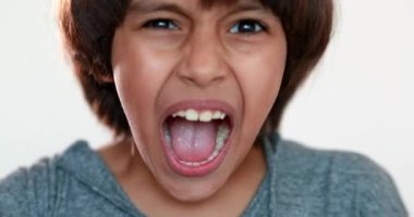 Üzgün çocuk çığlığı. Karışık ırk çocuğu kameraya kükreyerek bağırıyor, yakın plan sinirli çocuk yüzü