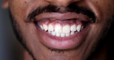 Dudakları makro yakın plan, siyah Afrikalı adam gülümsüyor.