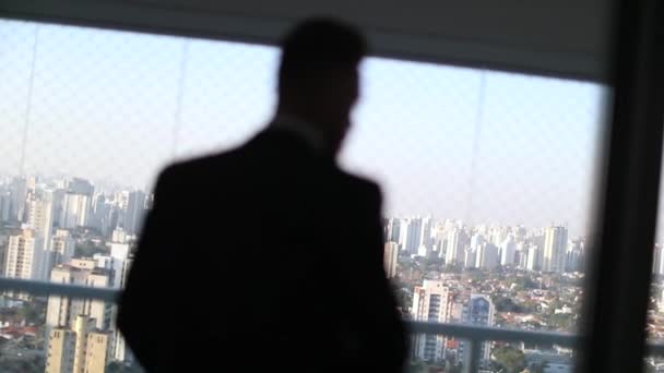 Business Man Removing Business Suit Window Overlooking Large Metropolitan City — Stock Video