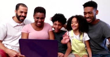 Video konferansında dizüstü bilgisayardaki akrabalarıyla konuşan Afrikalı ırklar arası aile.