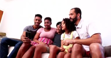 Mutlu siyah aile akıllı telefonuyla selfie çekiyor.